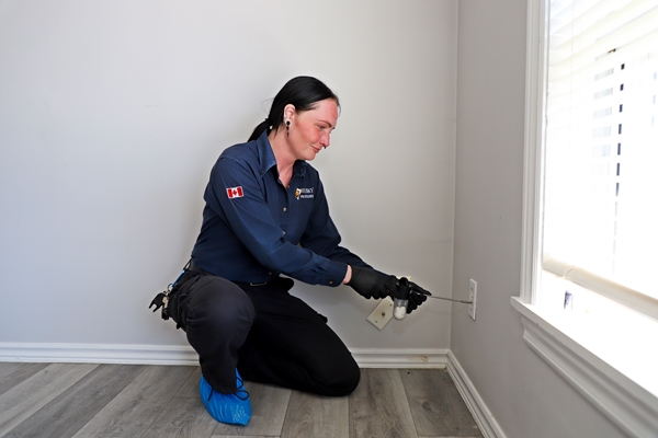 Husky Pest Control technician inspecting a multi-unit residential building